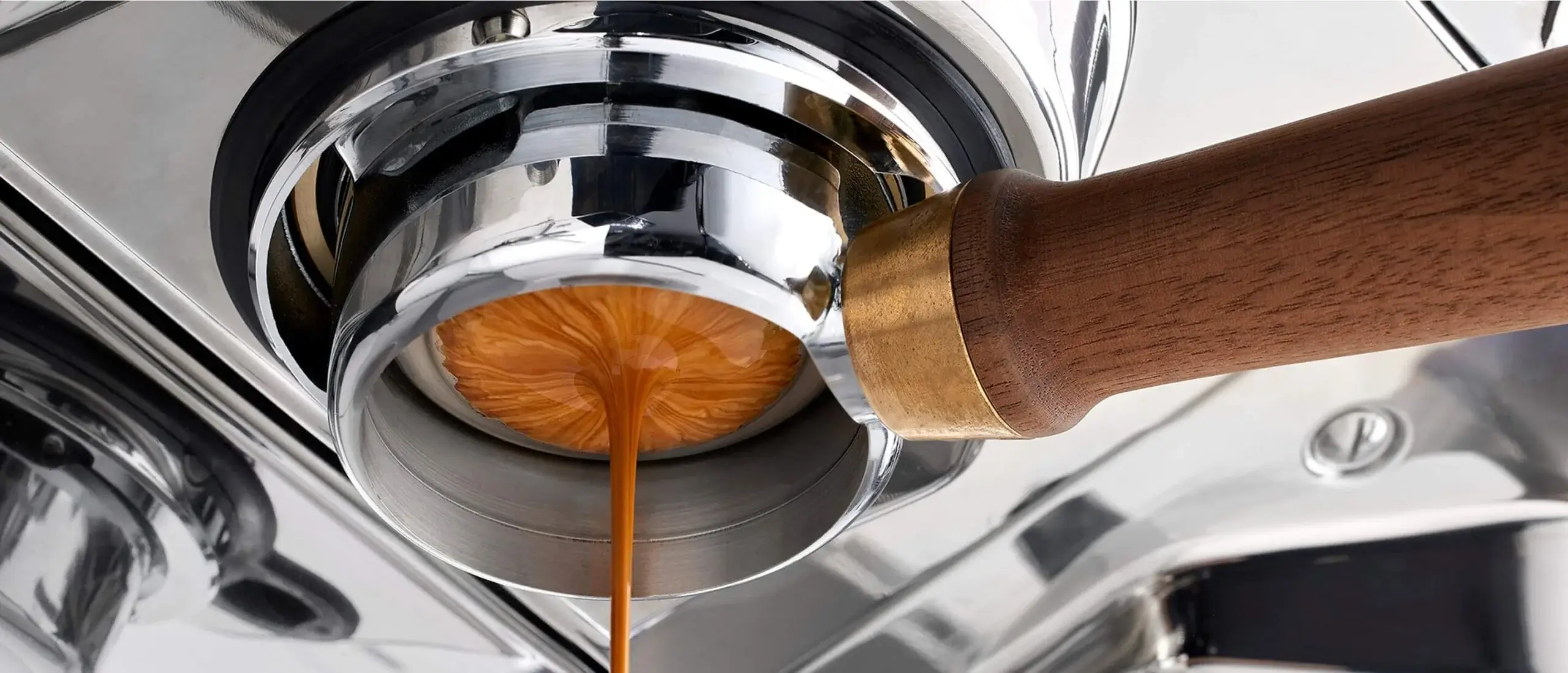 Espresso extraction through a wooden-handled bottomless portafilter on the UNIC Stella Epic